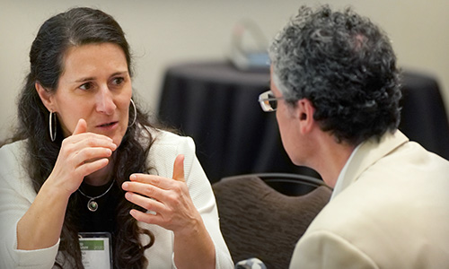 Colleagues sit and discuss current challenges in their area of work