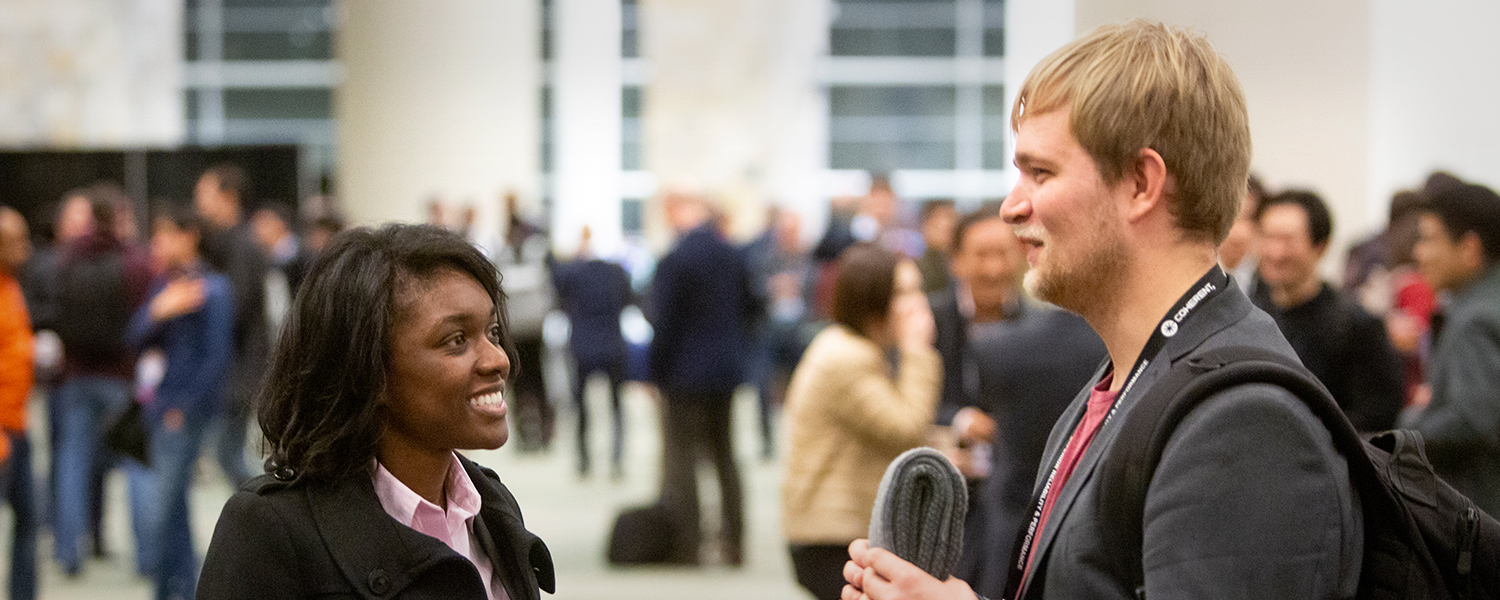 Attendees conversing at SPIE Smart Structures + NDE