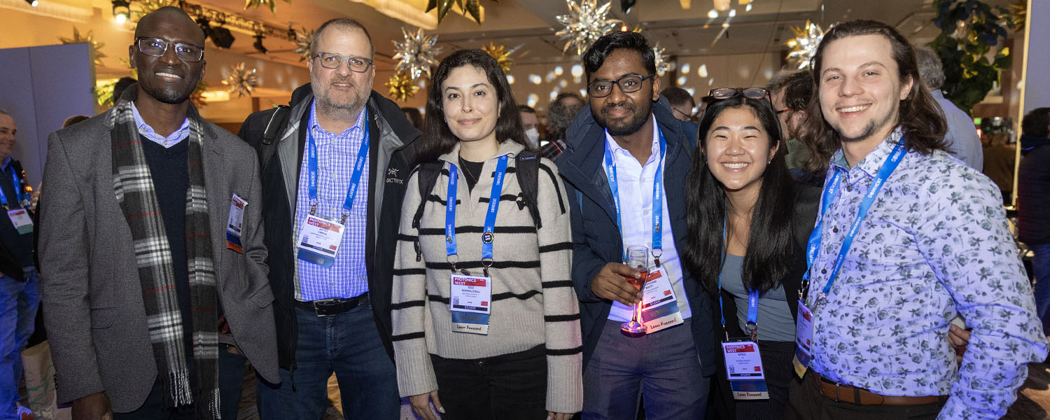 Six people stand together and enjoy the Welcome Reception at Photonics West