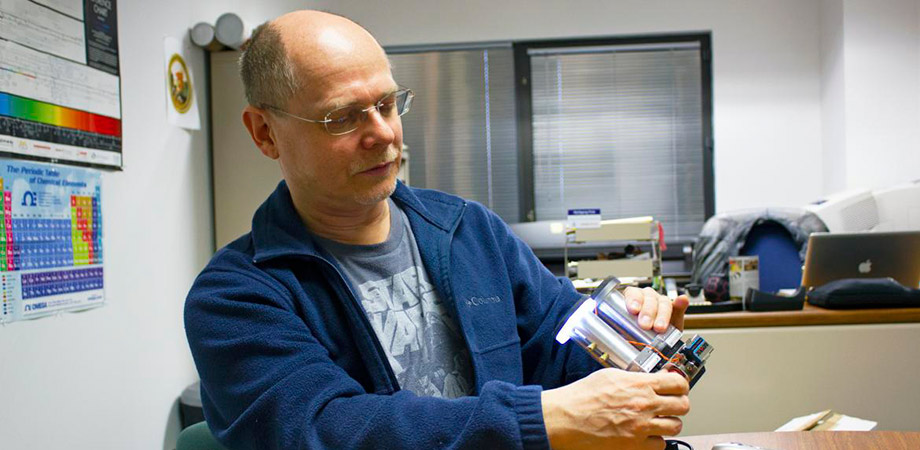 In a photo from 2020, Wolfgang Fink works with a patented opto-mechanical ocular sensor reader system which he devised and prototyped in his Visual and Autonomous Exploration Systems Research Laboratory. 